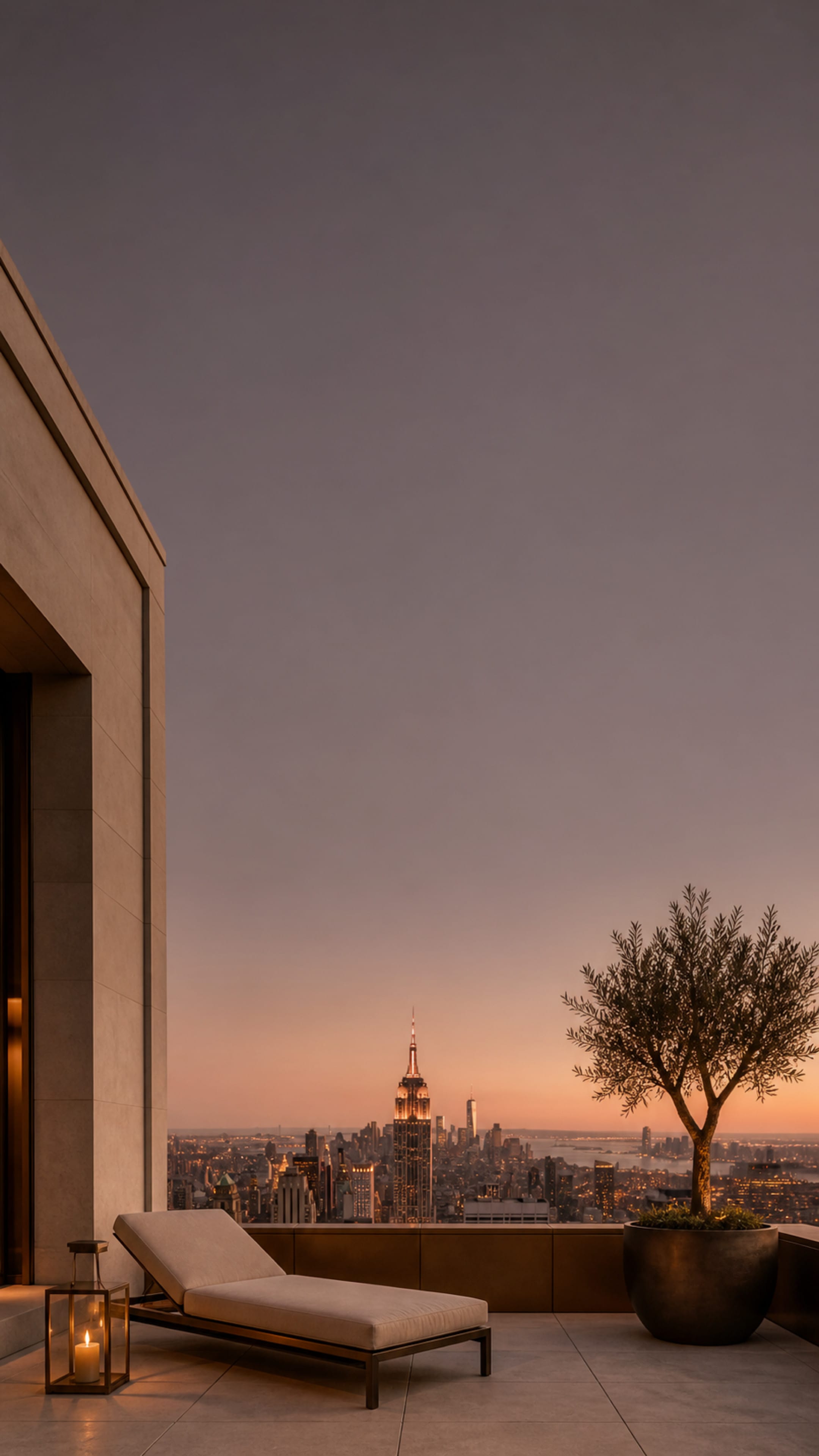 A penthouse terrace at sunset, the Empire State Building and Midtown beyond the parapet